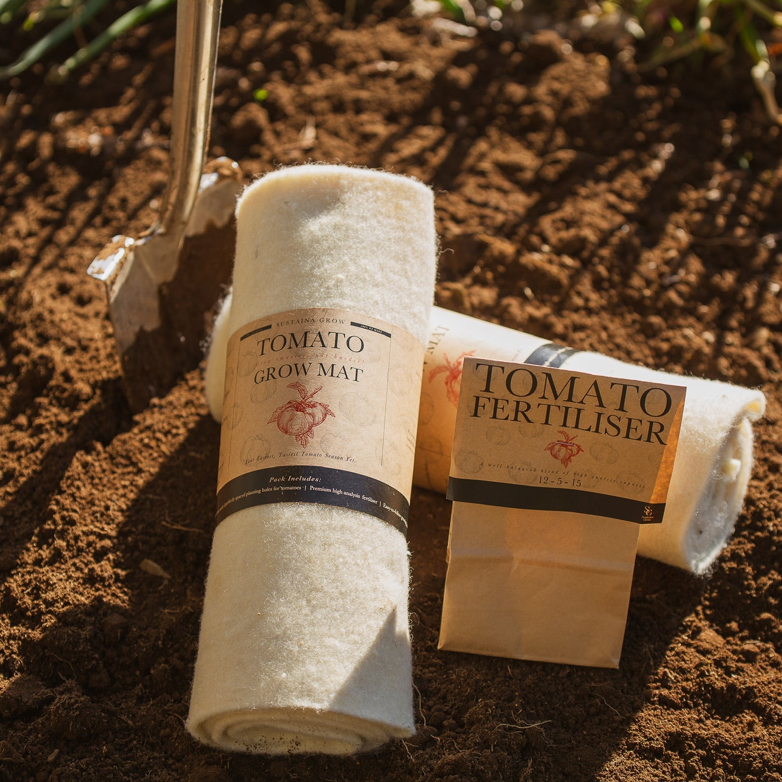 Roll of tomato grow mat and bag of tomato fertilizer on soil