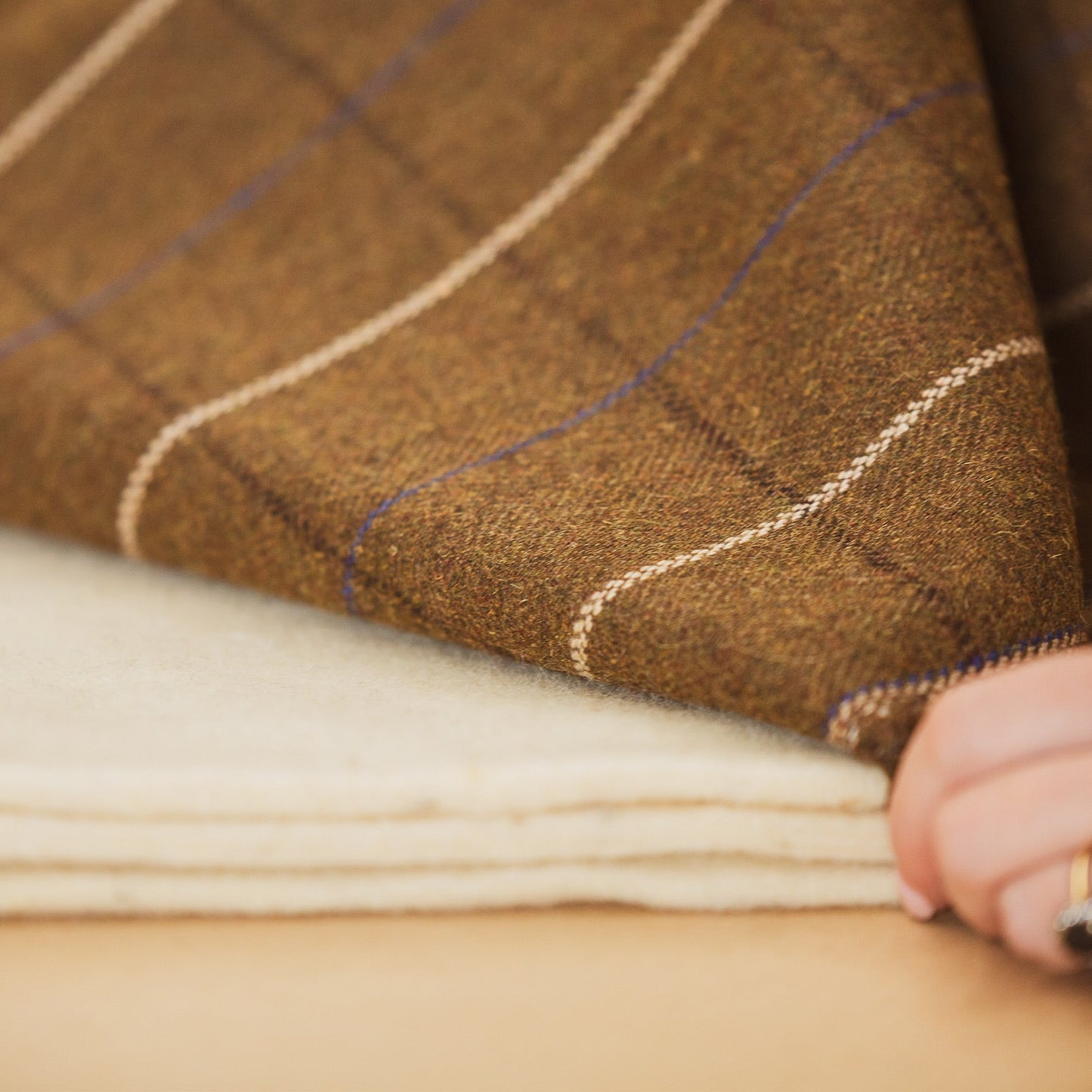 Close-up of brown and beige fabric with a hand holding it
